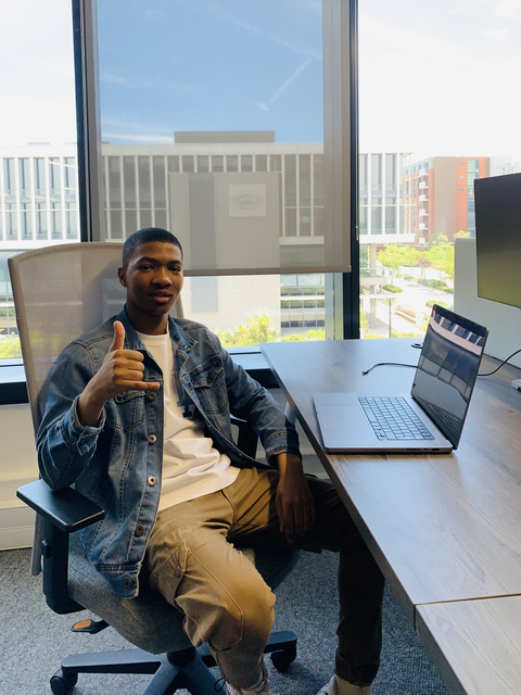 Iviwe seated at a desk beside a laptop